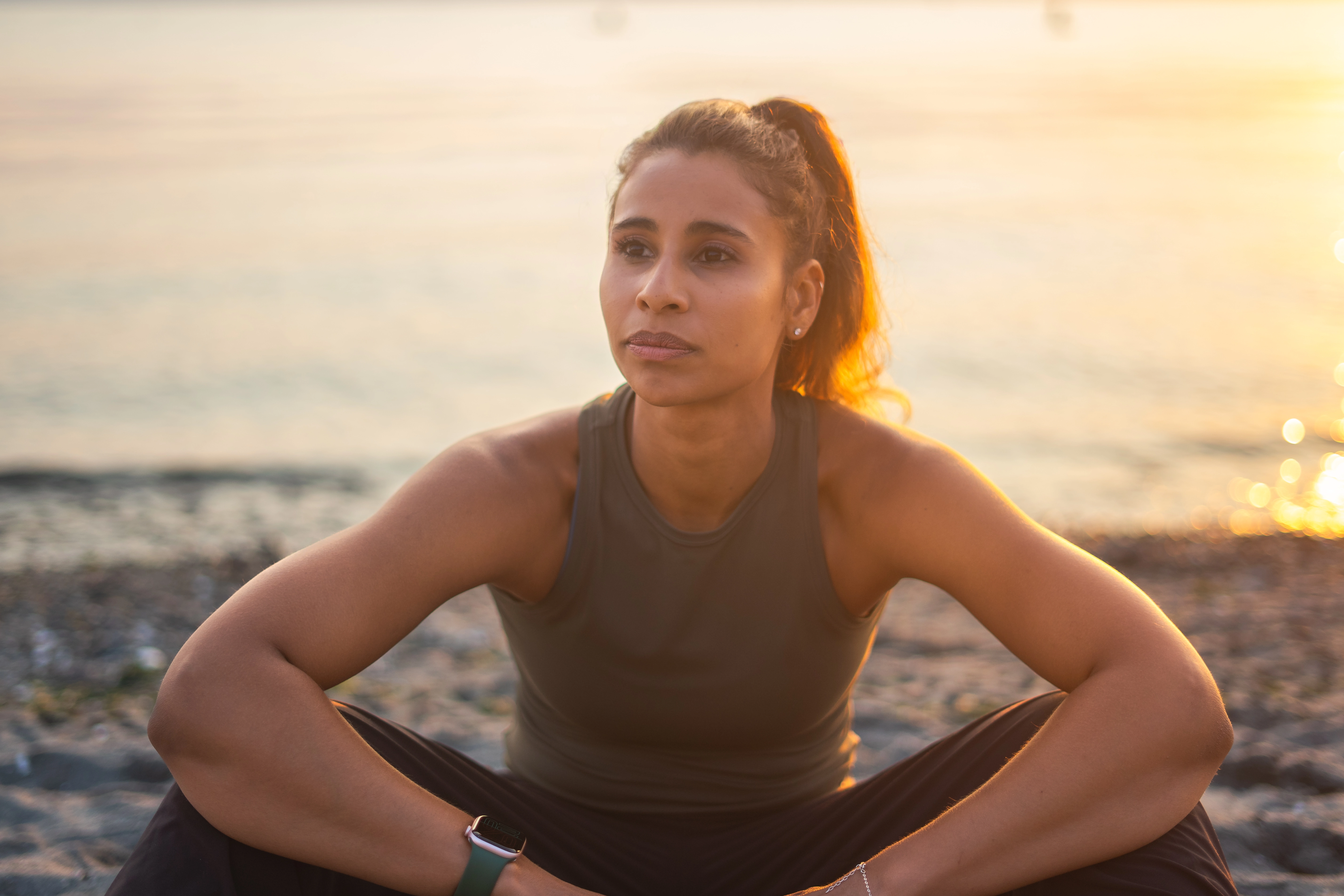 Cassie Sorgenfrey sitting on the beach in the sunset